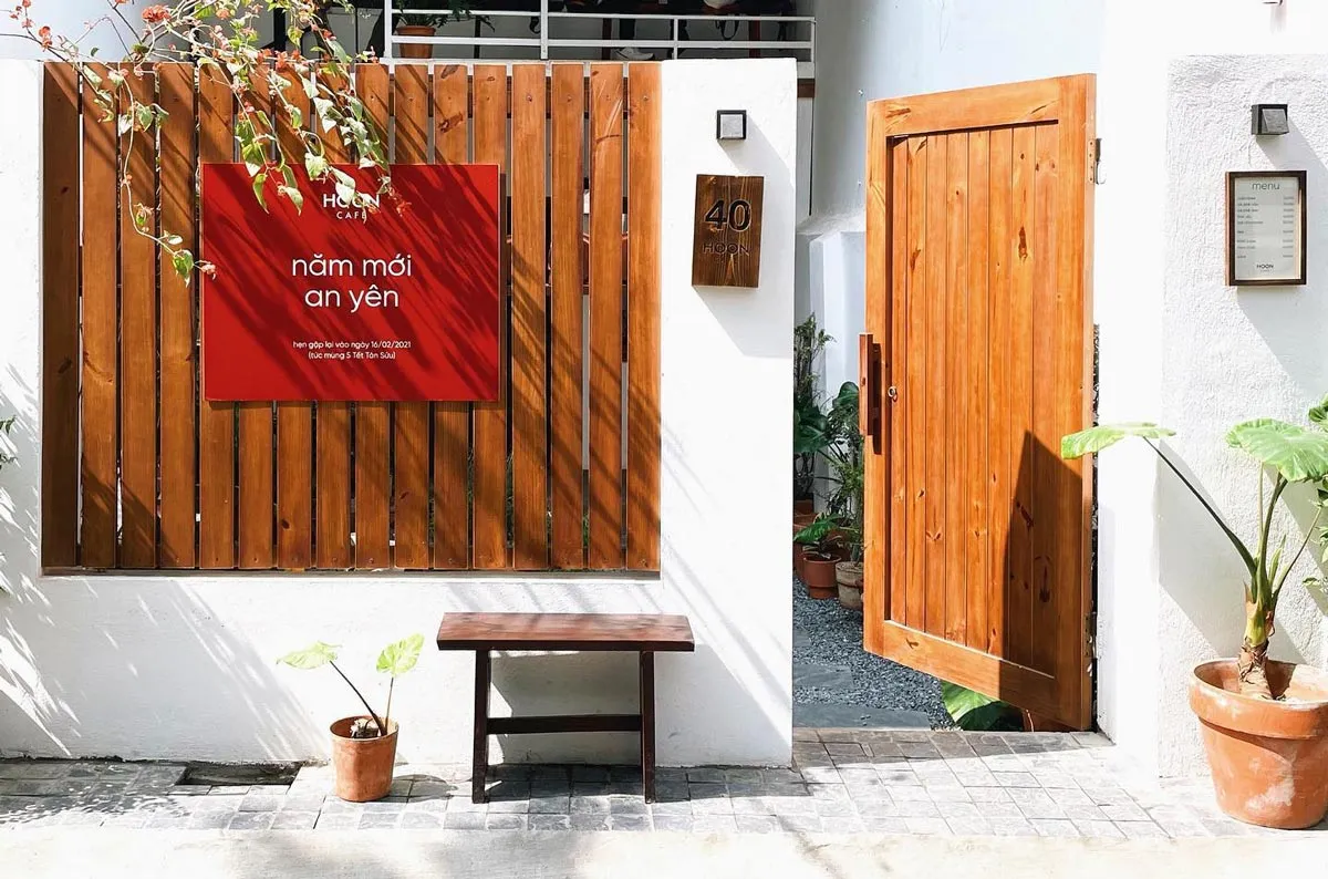 Sân HOON với bàn ghế gỗ và cây xanh